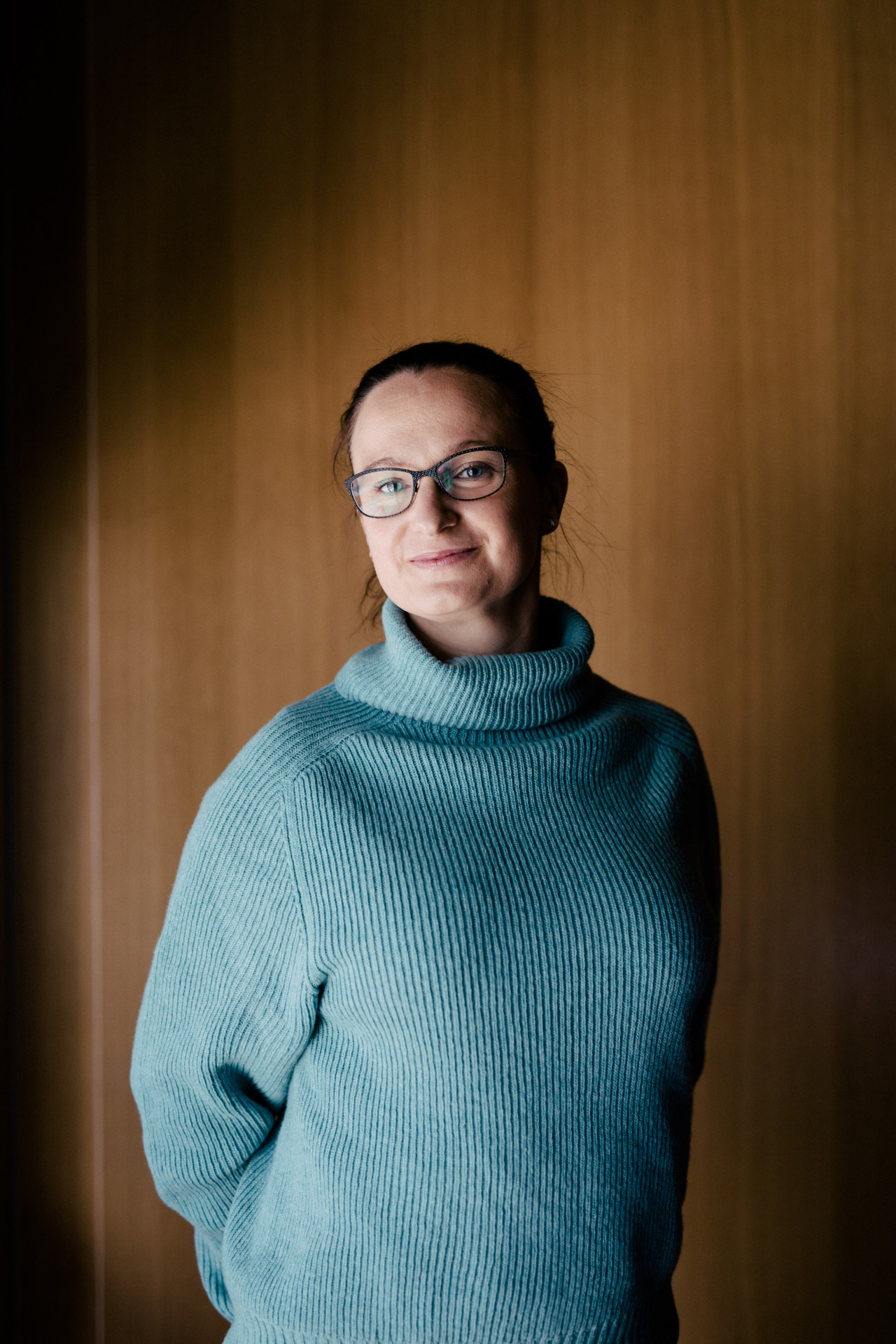 Shipiti töötaja naine naeratab kaamerasse helesinises kampsunis.